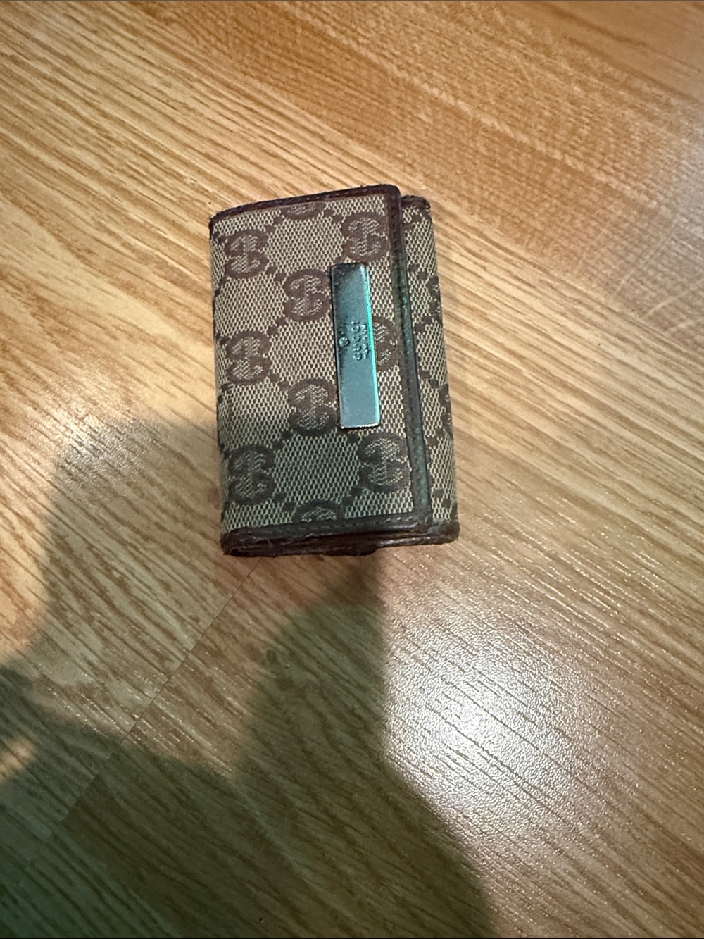 Gucci GG canvas key case featuring a brown leather trim & silver logo plaque